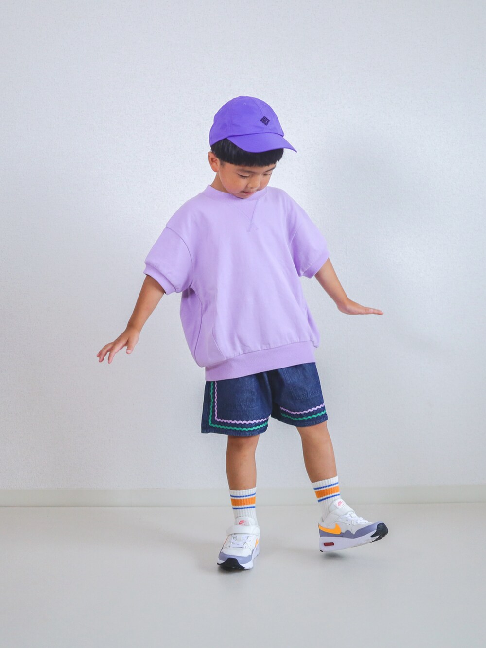 パープル系のTシャツ/カットソー、ブルー系のデニムパンツ、ホワイト系のスニーカーを着用したキッズの夏コーディネートの3枚目の写真
