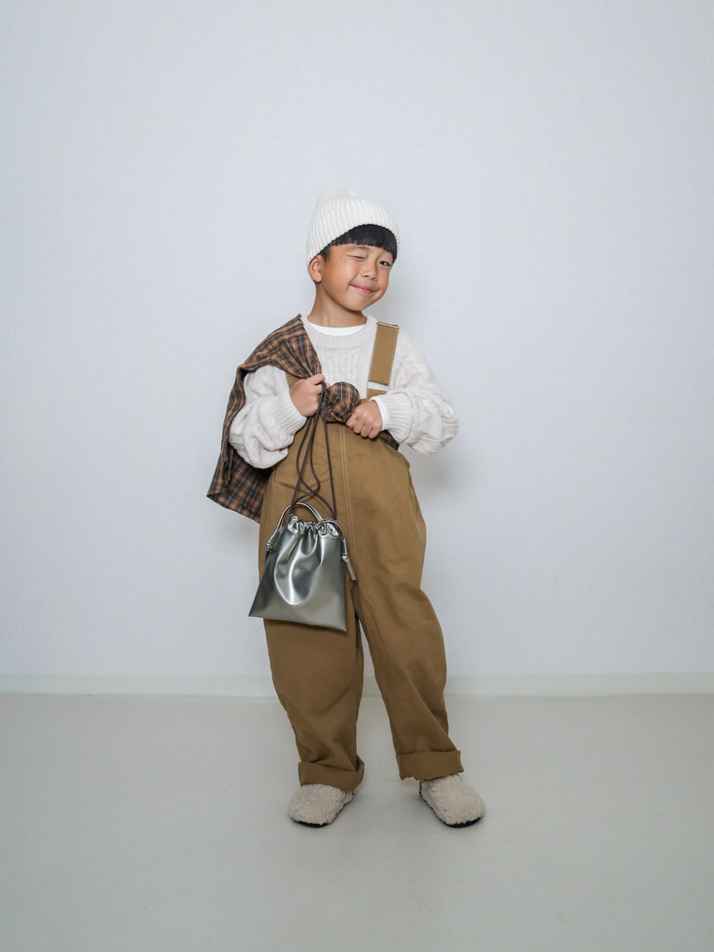ホワイト系のニット/セーター、ブラウン系のシャツ/ブラウス、ブラウン系のサロペット/オーバーオールを着用したキッズの秋コーディネートの2枚目の写真