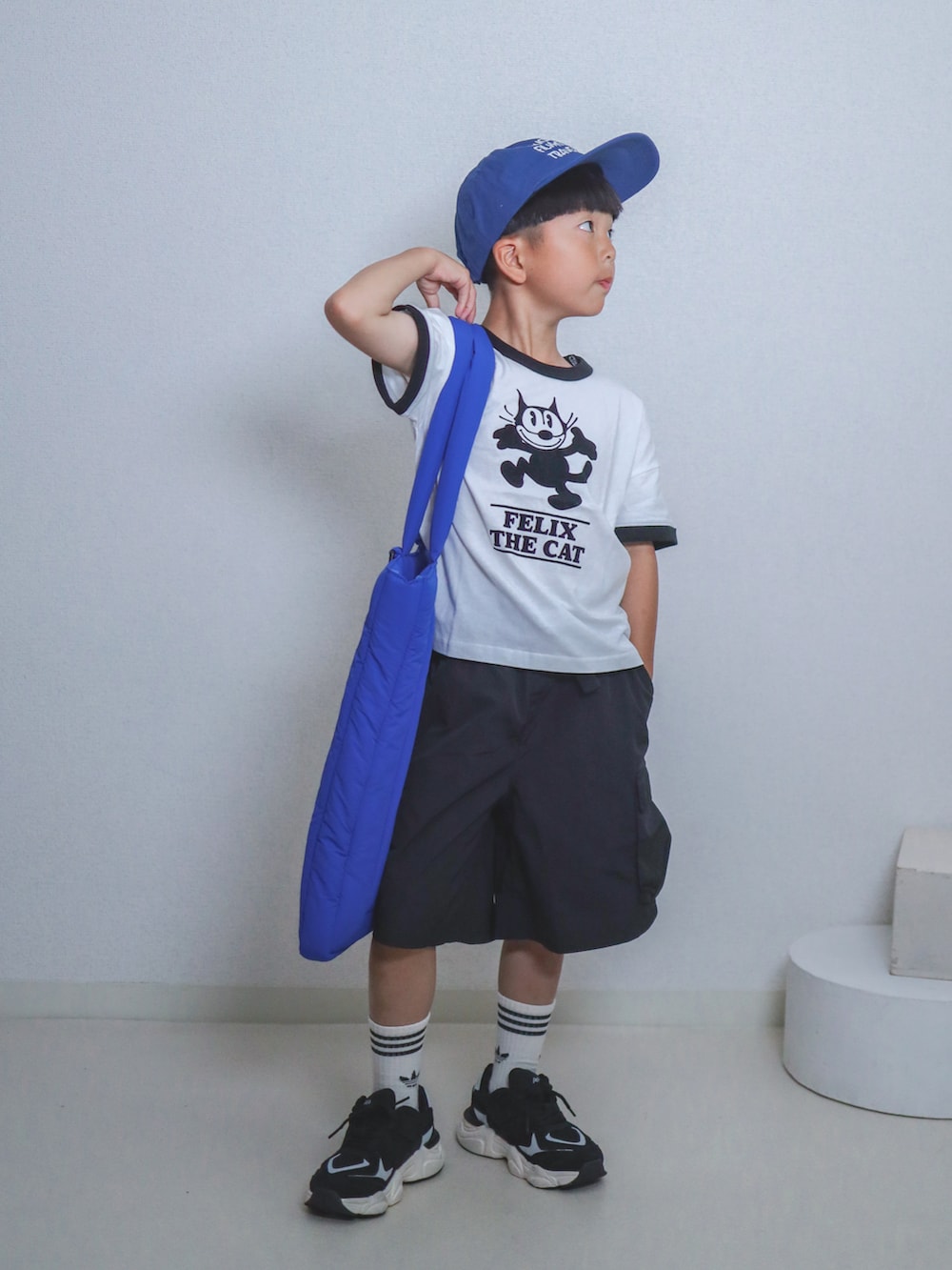 ホワイト系のTシャツ/カットソー、ブラック系のカーゴパンツ、ブルー系のトートバッグを着用したキッズの夏コーディネートの4枚目の写真