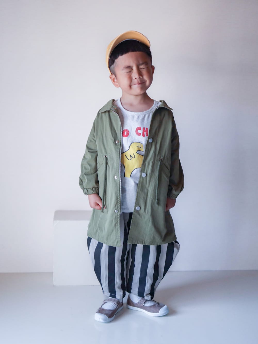 ブラック系のその他パンツ、ホワイト系のTシャツ/カットソー、グリーン系のショルダーバッグを着用したキッズの春コーディネートの2枚目の写真