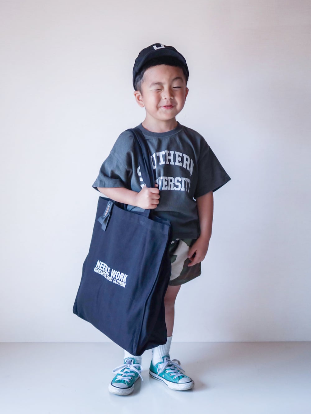 グレー系のTシャツ/カットソー、ブラック系のトートバッグ、グリーン系のスニーカーを着用したキッズの夏コーディネートの5枚目の写真