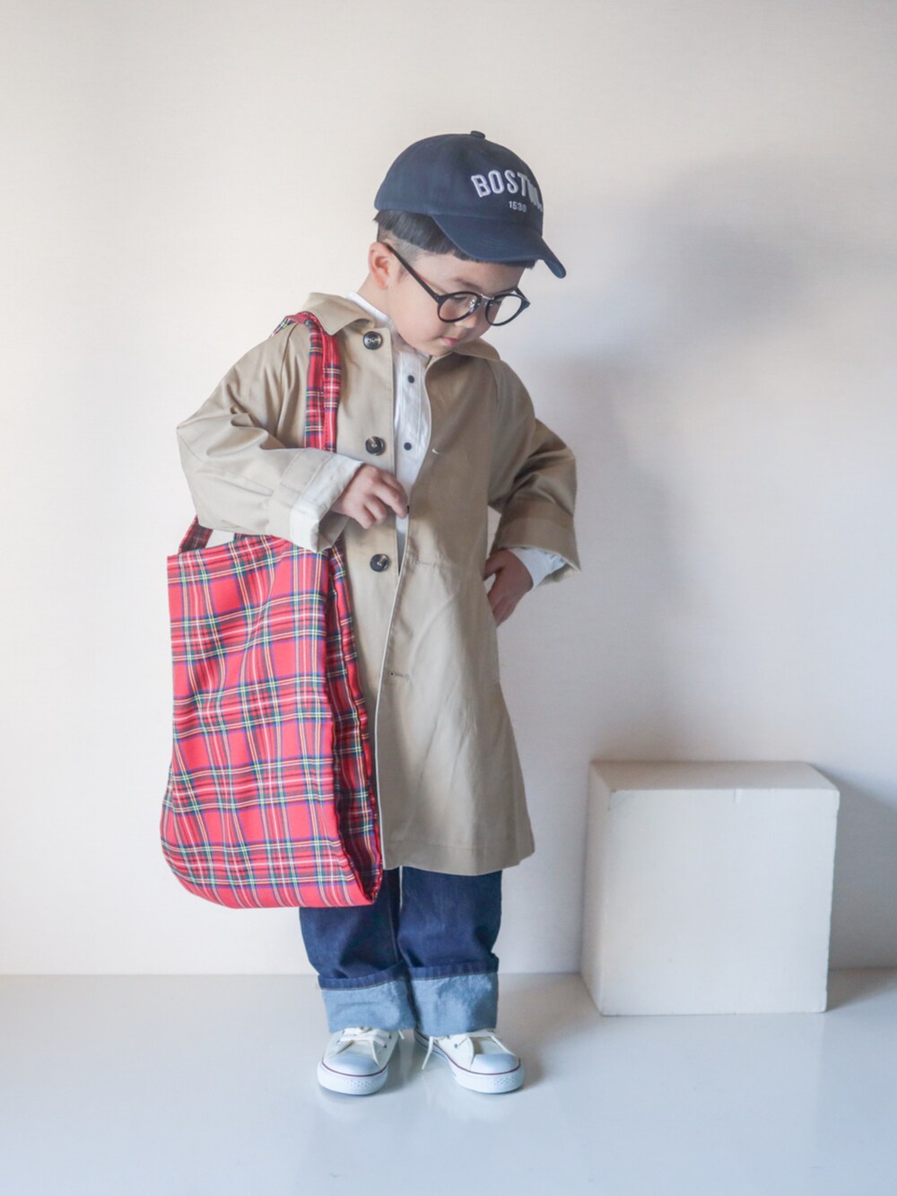 ベージュ系のステンカラーコート、ホワイト系のシャツ/ブラウス、ブルー系のデニムパンツを着用したキッズの春コーディネートの2枚目の写真