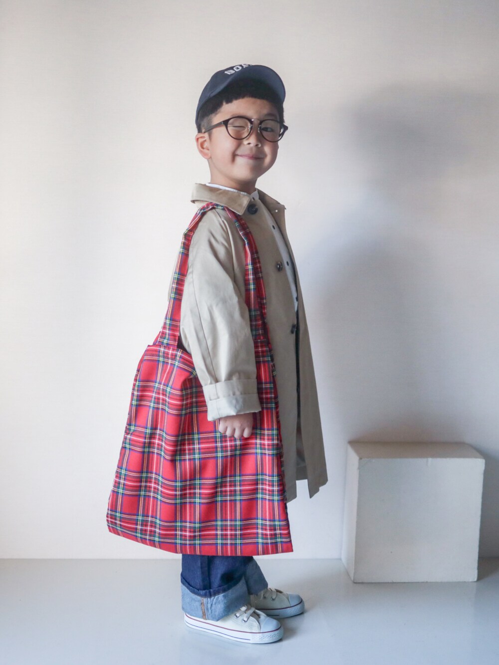 ベージュ系のステンカラーコート、ホワイト系のシャツ/ブラウス、ブルー系のデニムパンツを着用したキッズの春コーディネートの5枚目の写真