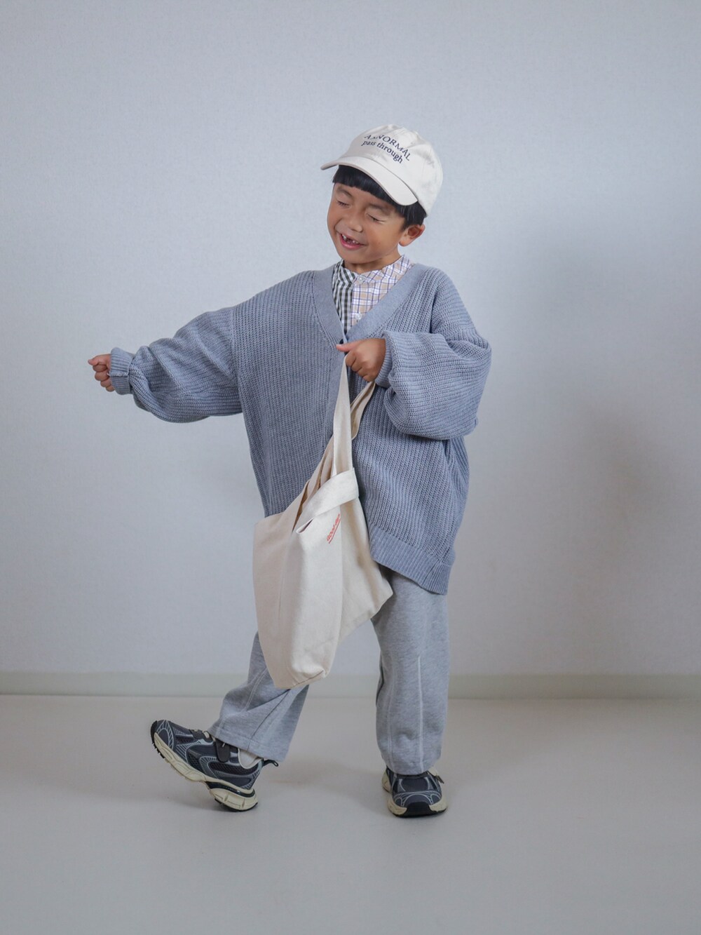 グレー系のカーディガン/ボレロ、グレー系のスウェットパンツ、ベージュ系のシャツ/ブラウスを着用したキッズの秋コーディネートの3枚目の写真