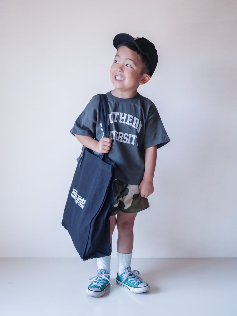 グレー系のTシャツ/カットソー、ブラック系のトートバッグ、グリーン系のスニーカーを着用したキッズの夏コーディネートの2枚目の写真