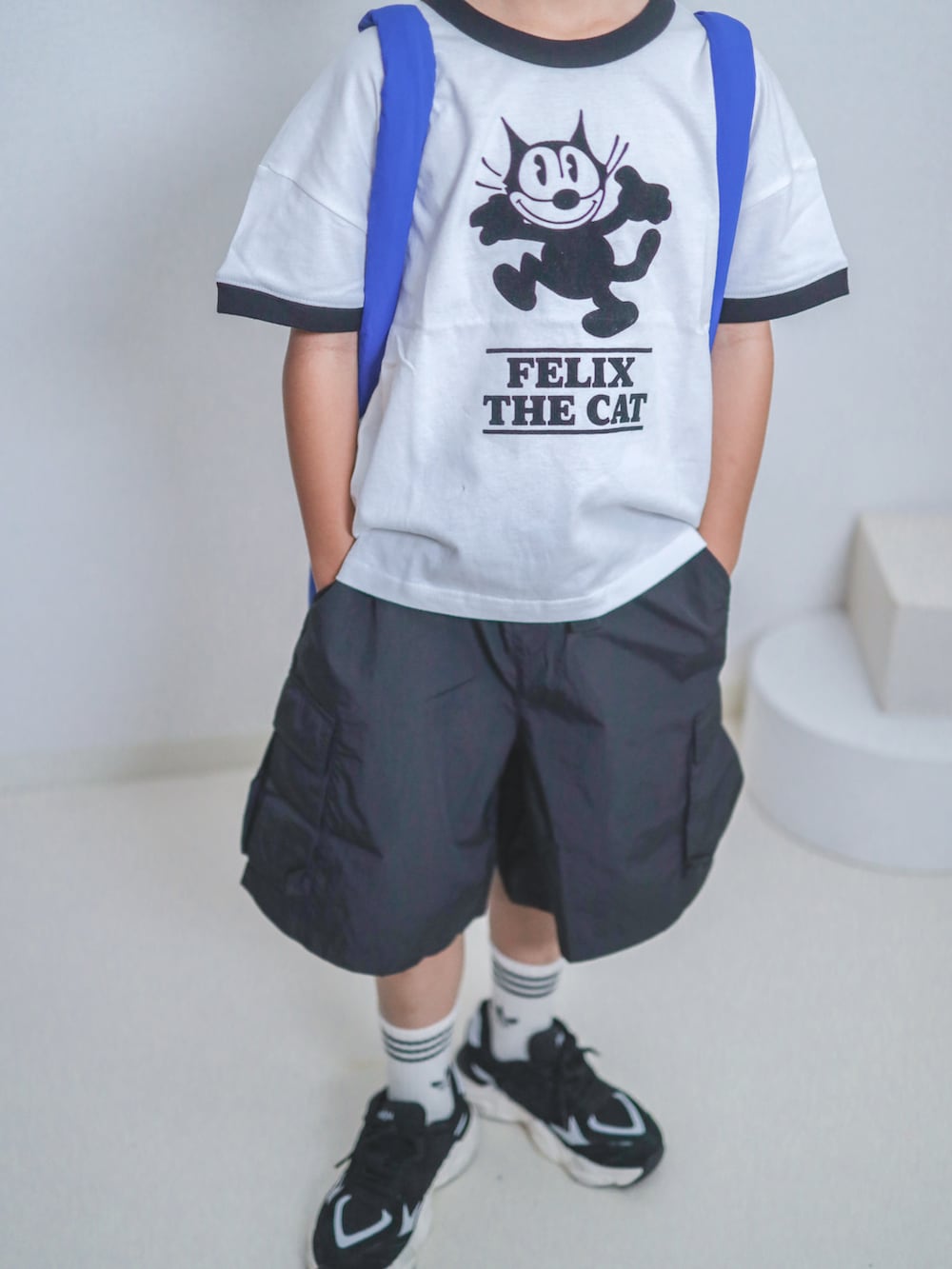 ホワイト系のTシャツ/カットソー、ブラック系のカーゴパンツ、ブルー系のトートバッグを着用したキッズの夏コーディネートの3枚目の写真