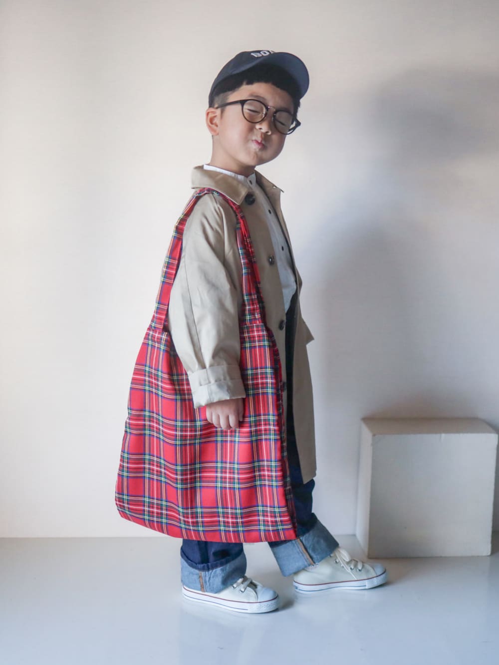 ベージュ系のステンカラーコート、ホワイト系のシャツ/ブラウス、ブルー系のデニムパンツを着用したキッズの春コーディネートの3枚目の写真