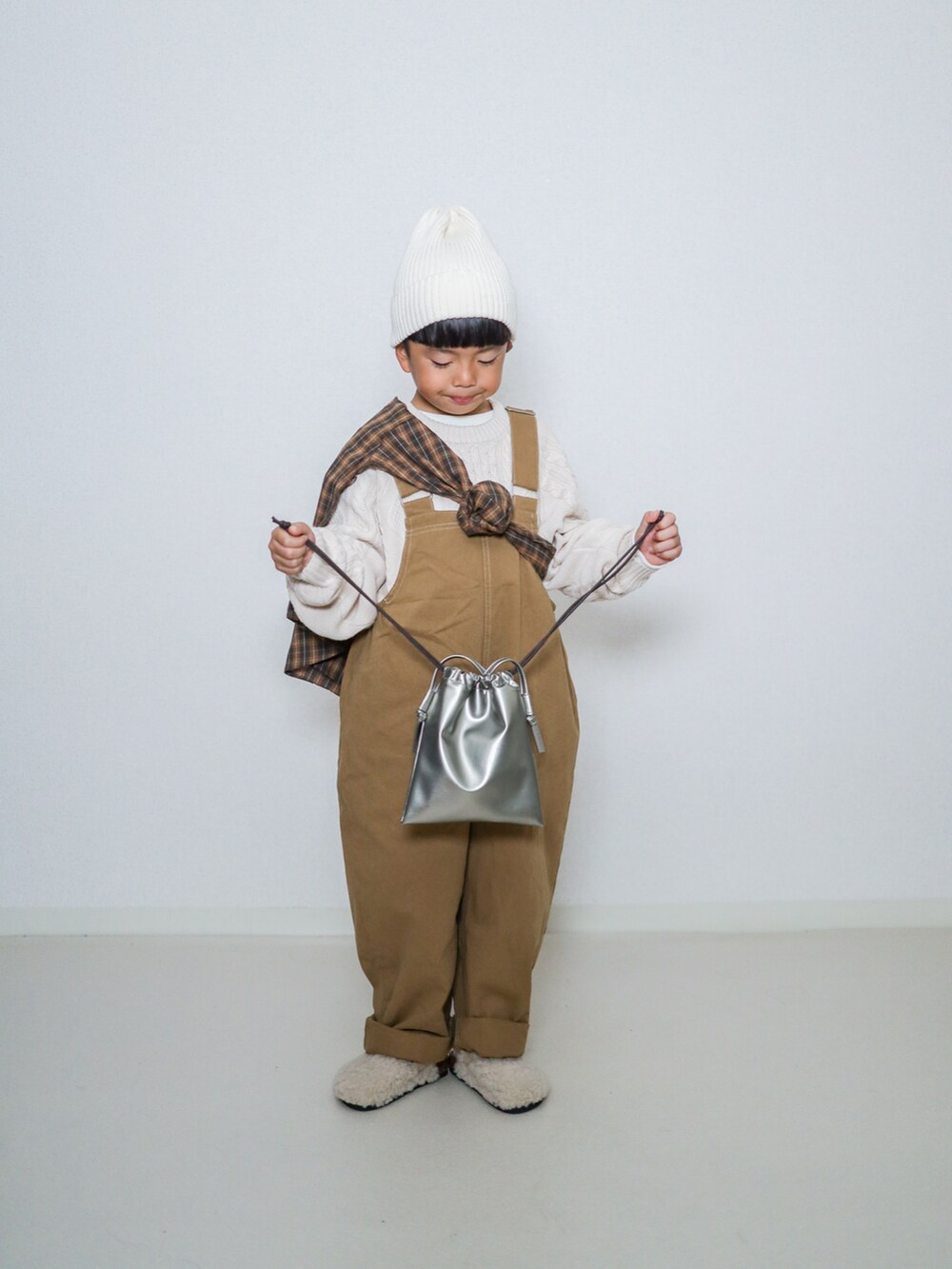 ホワイト系のニット/セーター、ブラウン系のシャツ/ブラウス、ブラウン系のサロペット/オーバーオールを着用したキッズの秋コーディネートの3枚目の写真