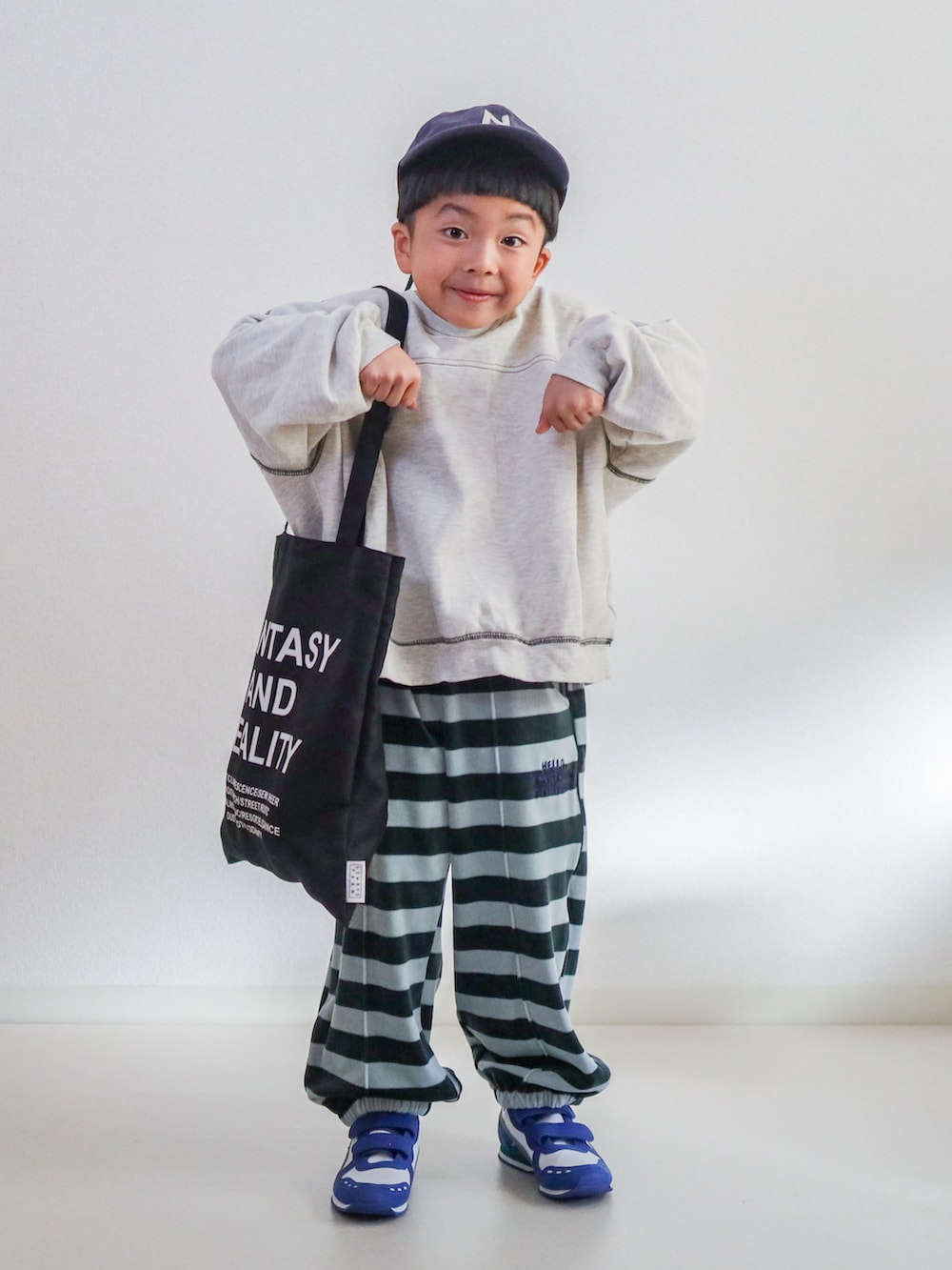 ブルー系のスウェットパンツ、ベージュ系のスウェット、ホワイト系のスニーカーを着用したキッズの冬コーディネートの2枚目の写真