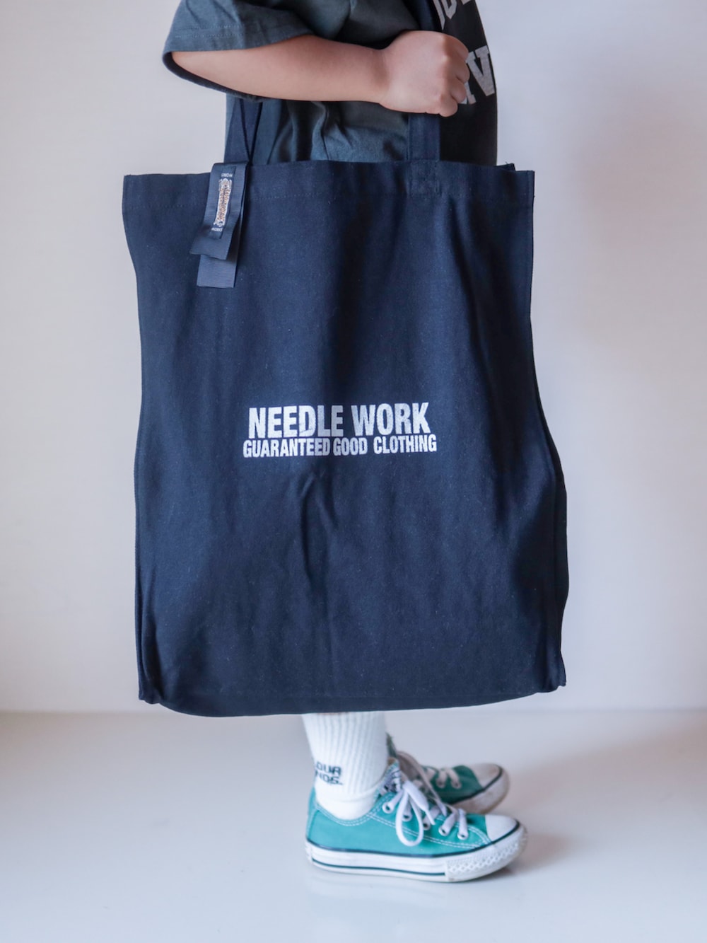 グレー系のTシャツ/カットソー、ブラック系のトートバッグ、グリーン系のスニーカーを着用したキッズの夏コーディネートの4枚目の写真