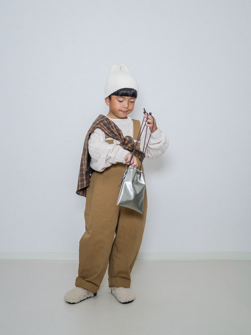 ホワイト系のニット/セーター、ブラウン系のシャツ/ブラウス、ブラウン系のサロペット/オーバーオールを着用したキッズの秋コーディネートの5枚目の写真