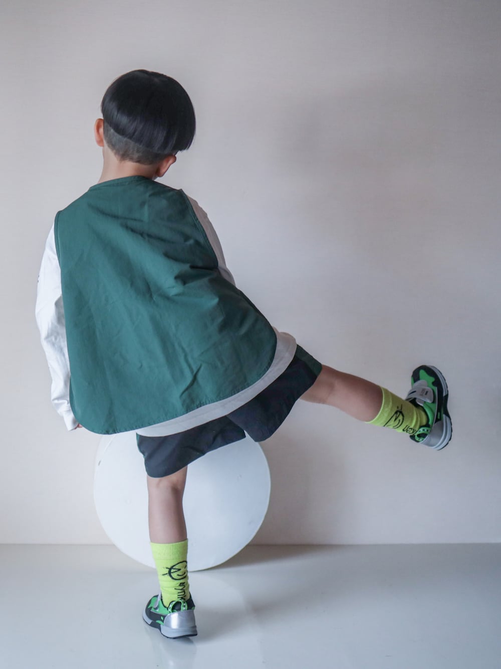 グリーン系のベスト、ブラック系のその他パンツ、グリーン系のシューズを着用したキッズの春コーディネートの5枚目の写真