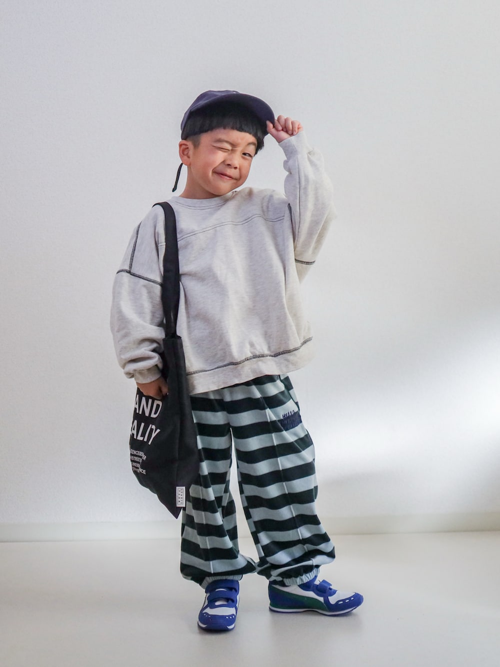 ブルー系のスウェットパンツ、ベージュ系のスウェット、ホワイト系のスニーカーを着用したキッズの冬コーディネートの5枚目の写真