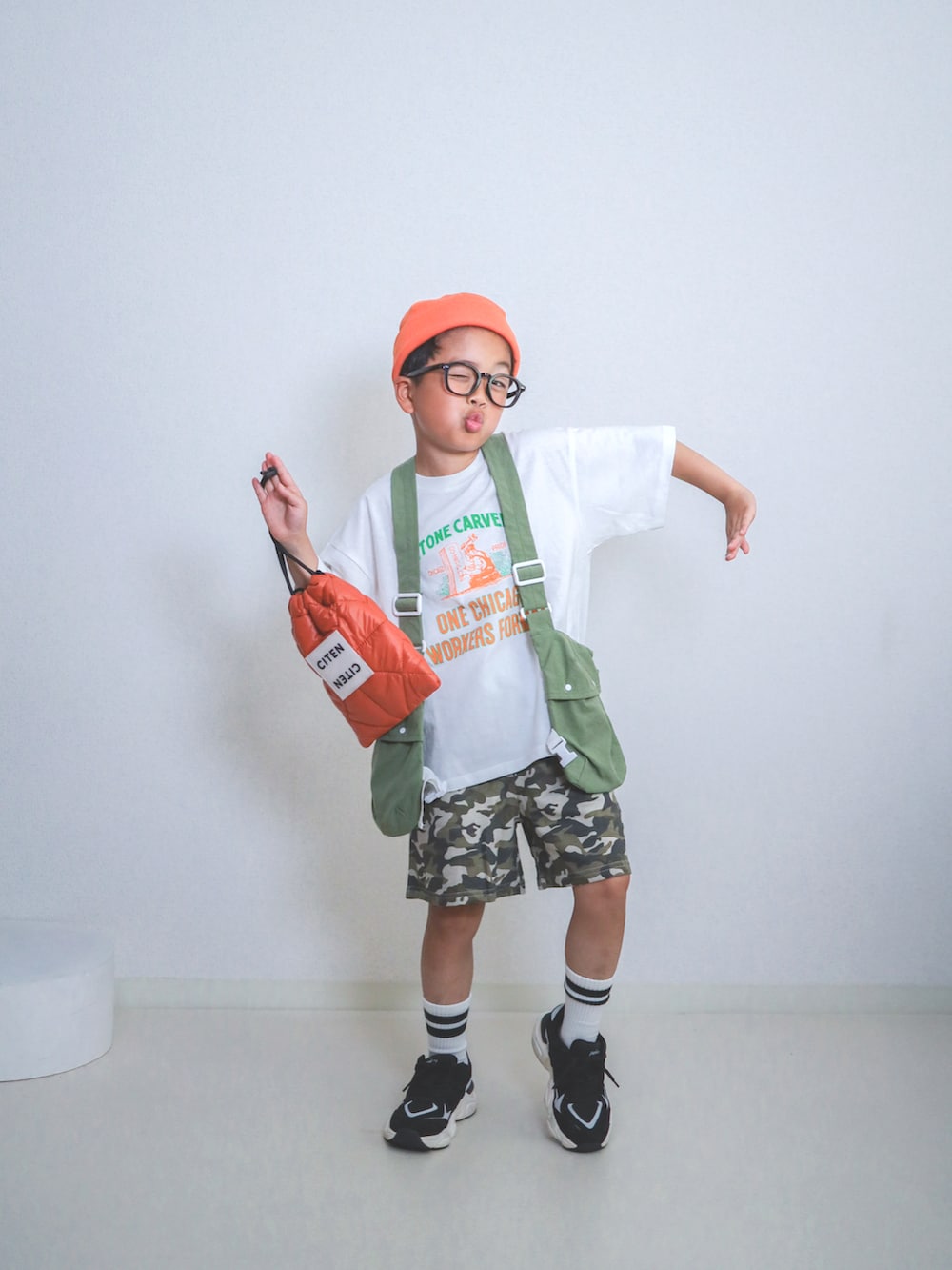 グリーン系のスウェットパンツ、ホワイト系のTシャツ/カットソー、オレンジ系のショルダーバッグを着用したキッズの春コーディネートの4枚目の写真