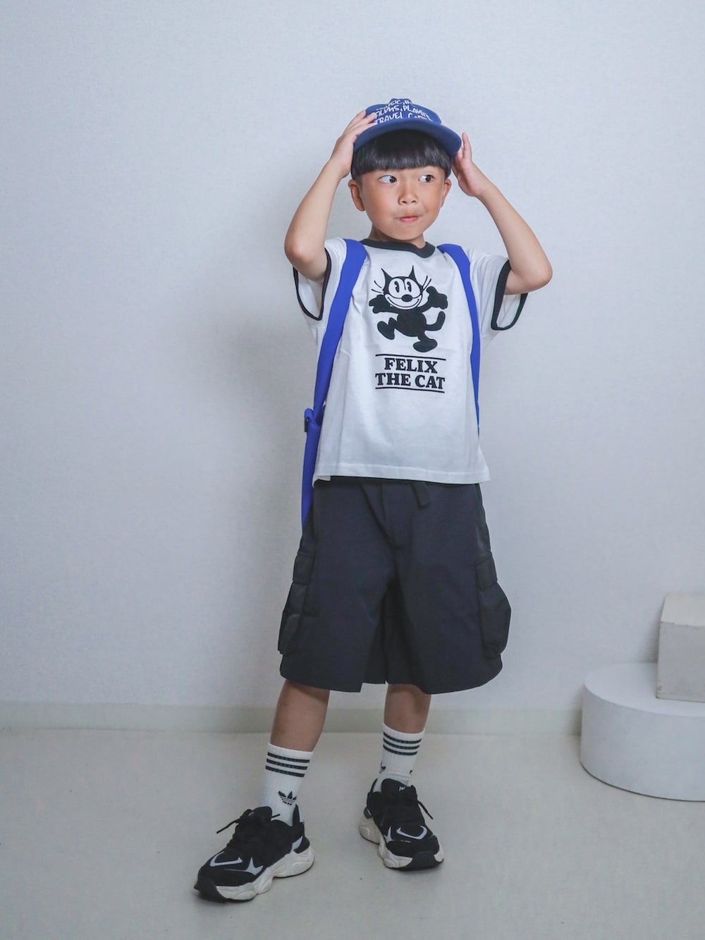 ホワイト系のTシャツ/カットソー、ブラック系のカーゴパンツ、ブルー系のトートバッグを着用したキッズの夏コーディネートの2枚目の写真