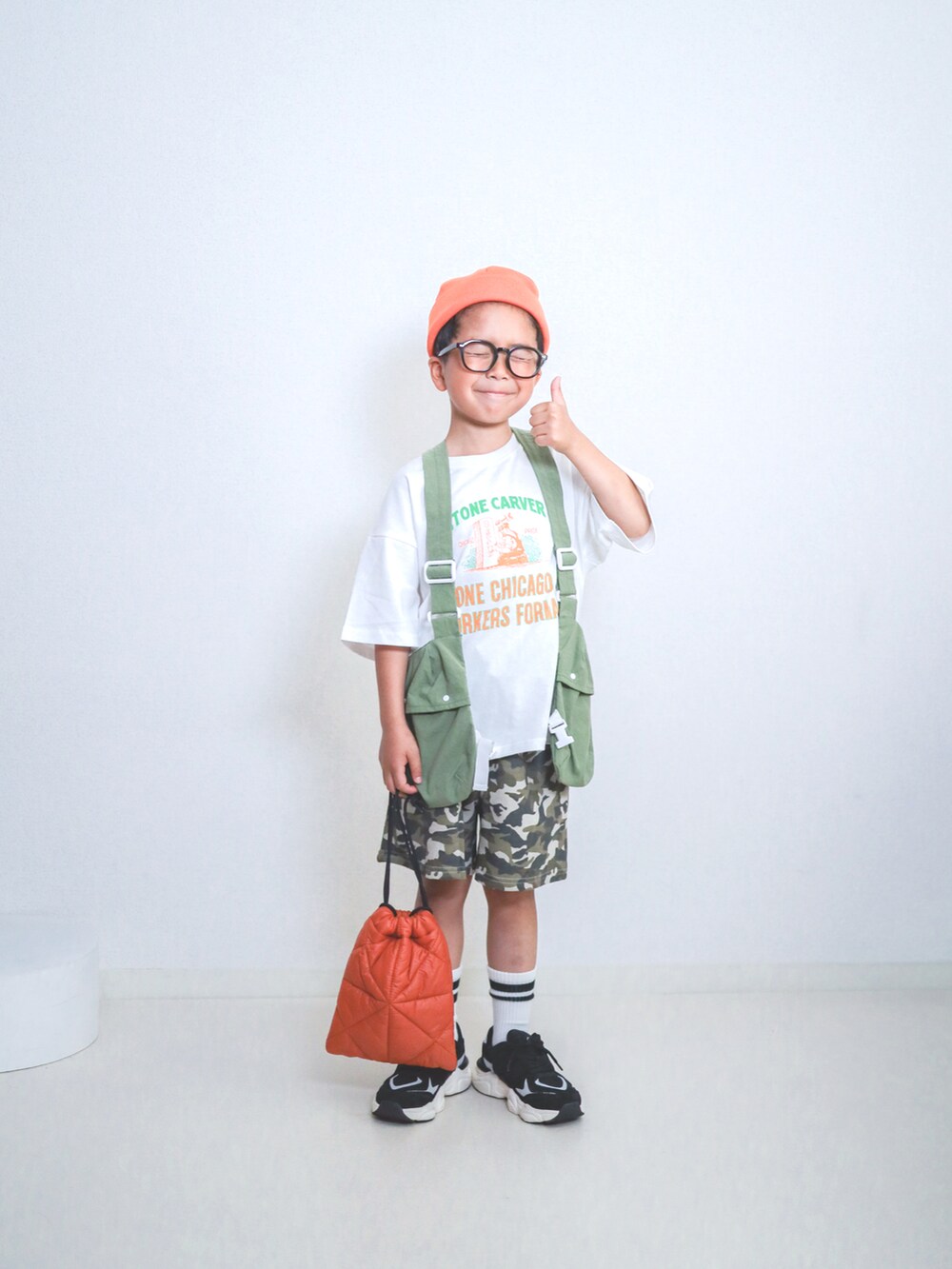 グリーン系のスウェットパンツ、ホワイト系のTシャツ/カットソー、オレンジ系のショルダーバッグを着用したキッズの春コーディネートの5枚目の写真