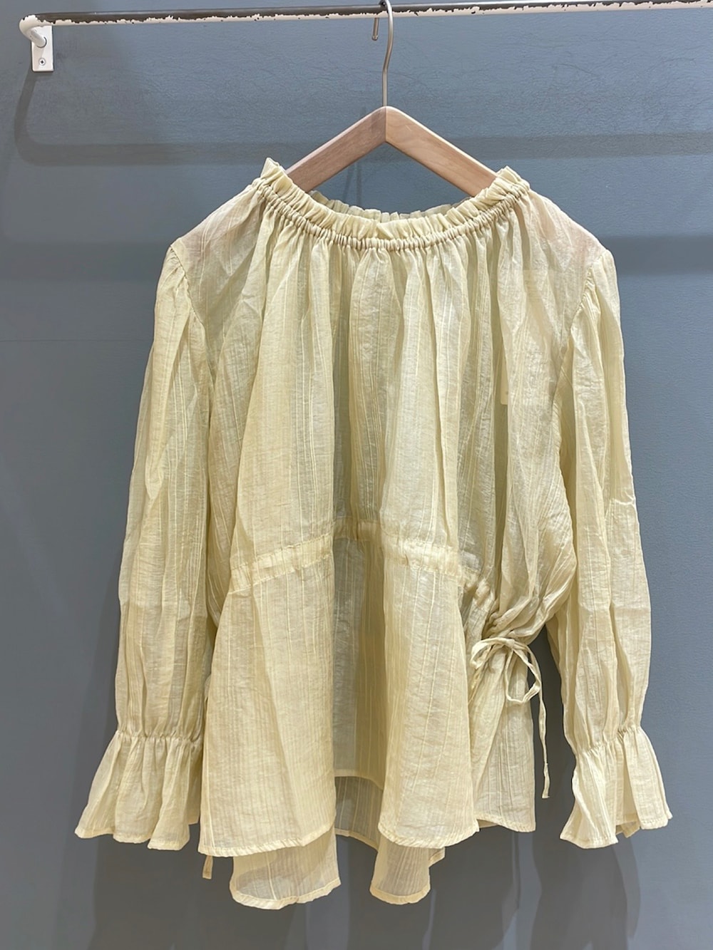 イエロー系のシャツ/ブラウスを着用したレディースの夏コーディネートの2枚目の写真