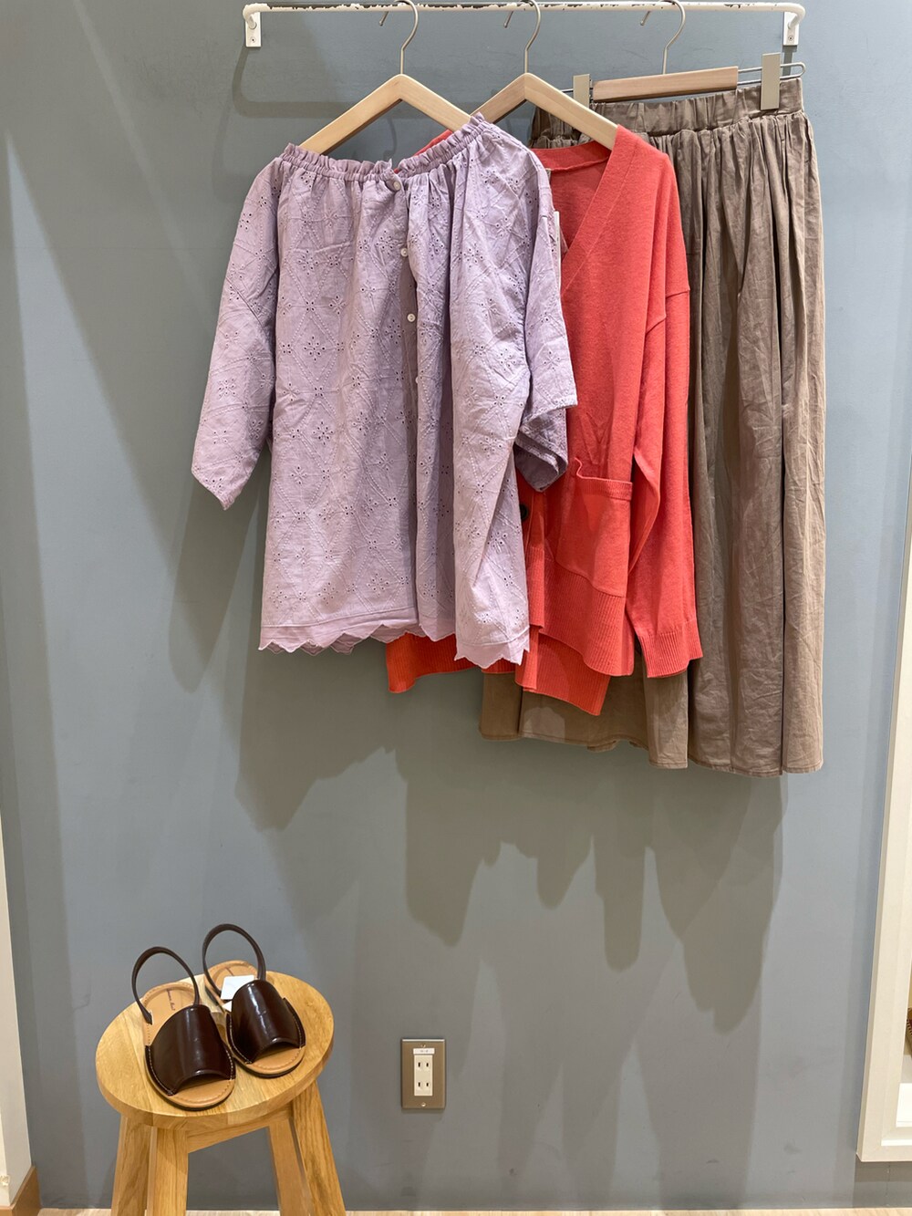 パープル系のシャツ/ブラウス、ピンク系のカーディガン/ボレロ、ブラウン系のスカートを着用したレディースの春コーディネートの2枚目の写真