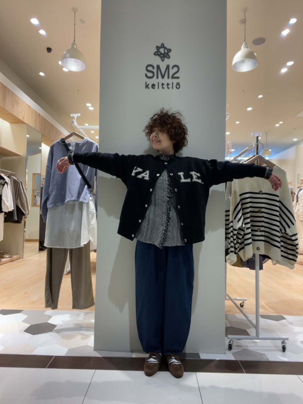 ブラック系のトップス、ブルー系のデニムパンツ、ブラック系のシャツ/ブラウスを着用したレディースの秋コーディネートの5枚目の写真