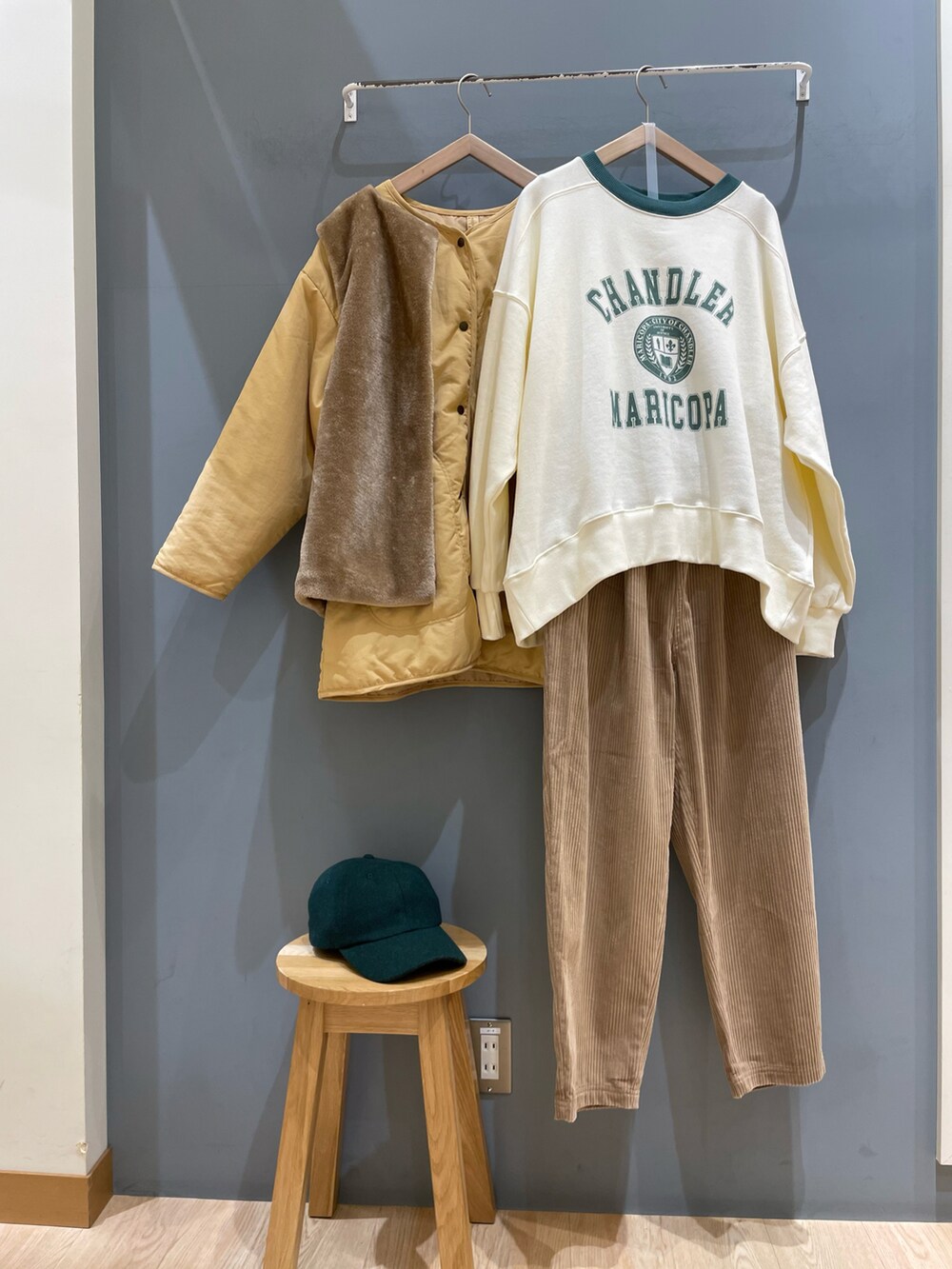 イエロー系のブルゾン、グリーン系のTシャツ/カットソー、ベージュ系のパンツを着用したレディースの冬コーディネートの5枚目の写真