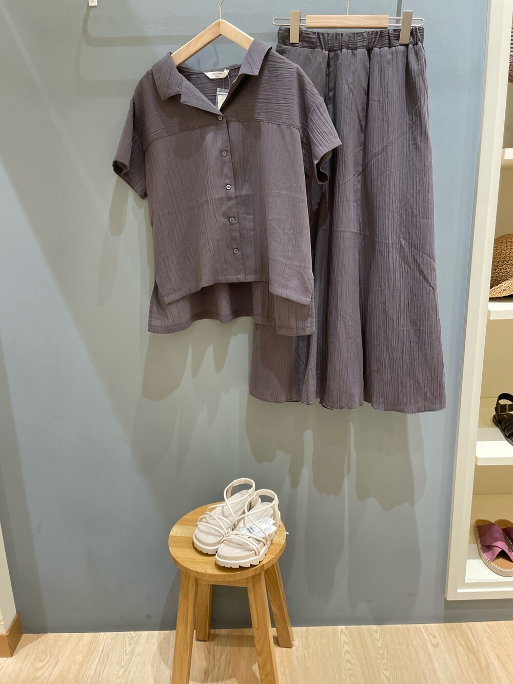 グレー系のシャツ/ブラウス、グレー系のスカート、ホワイト系のサンダルを着用したレディースの春コーディネートの2枚目の写真