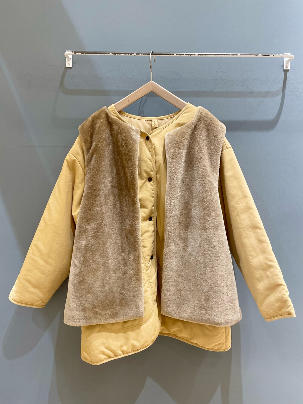 イエロー系のブルゾン、グリーン系のTシャツ/カットソー、ベージュ系のパンツを着用したレディースの冬コーディネートの2枚目の写真