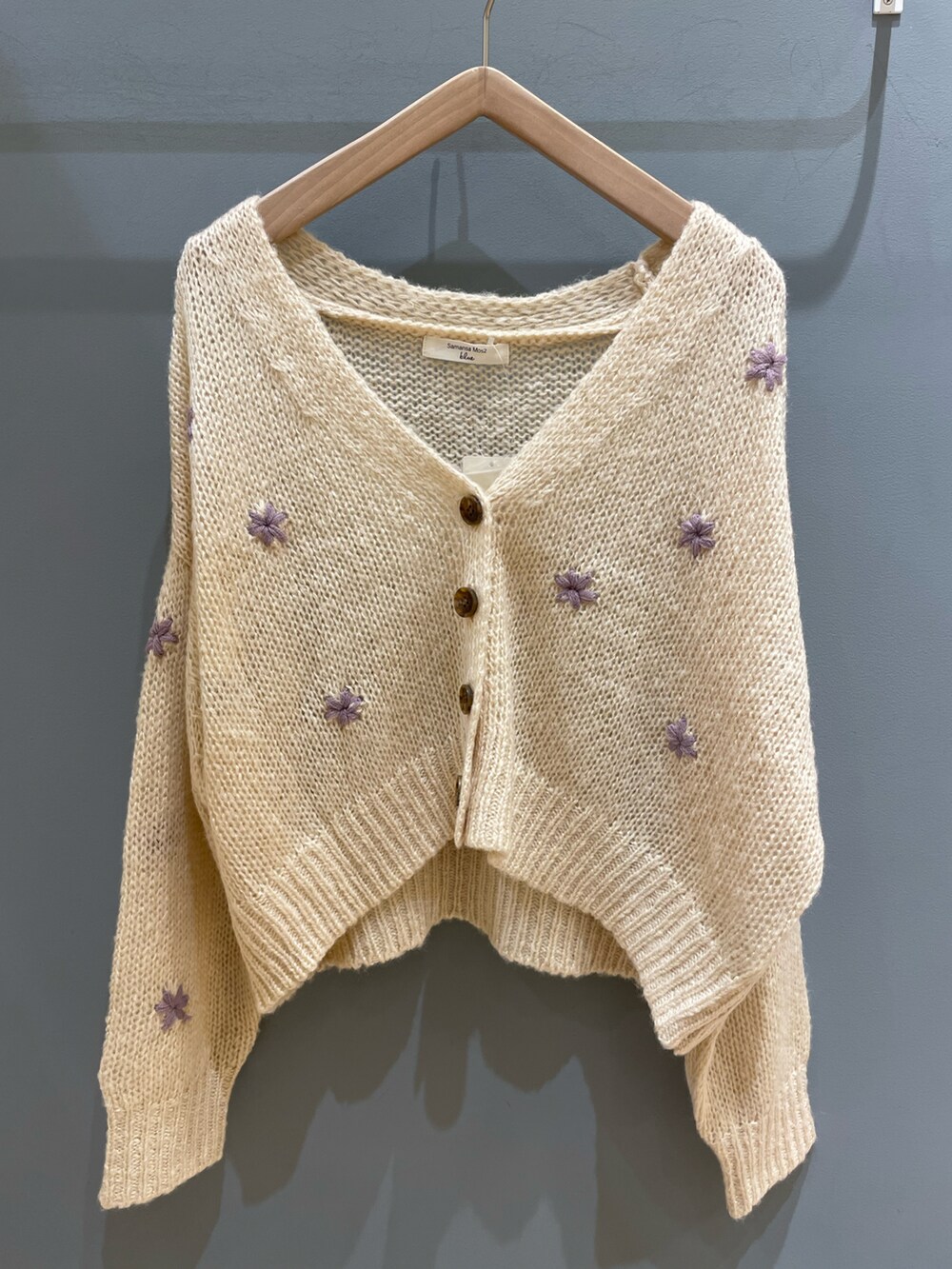 ベージュ系のカーディガン/ボレロ、ホワイト系のTシャツ/カットソー、レッド系のスカートを着用したレディースの秋コーディネートの5枚目の写真