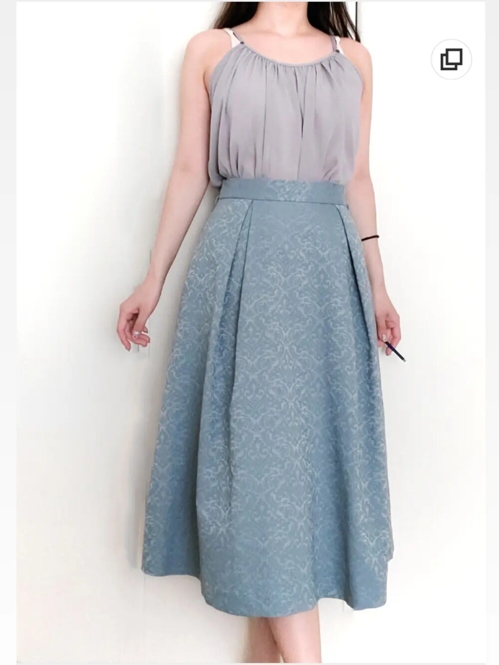 パープル系のキャミソール、ブルー系のスカートを着用したレディースの夏コーディネートの3枚目の写真