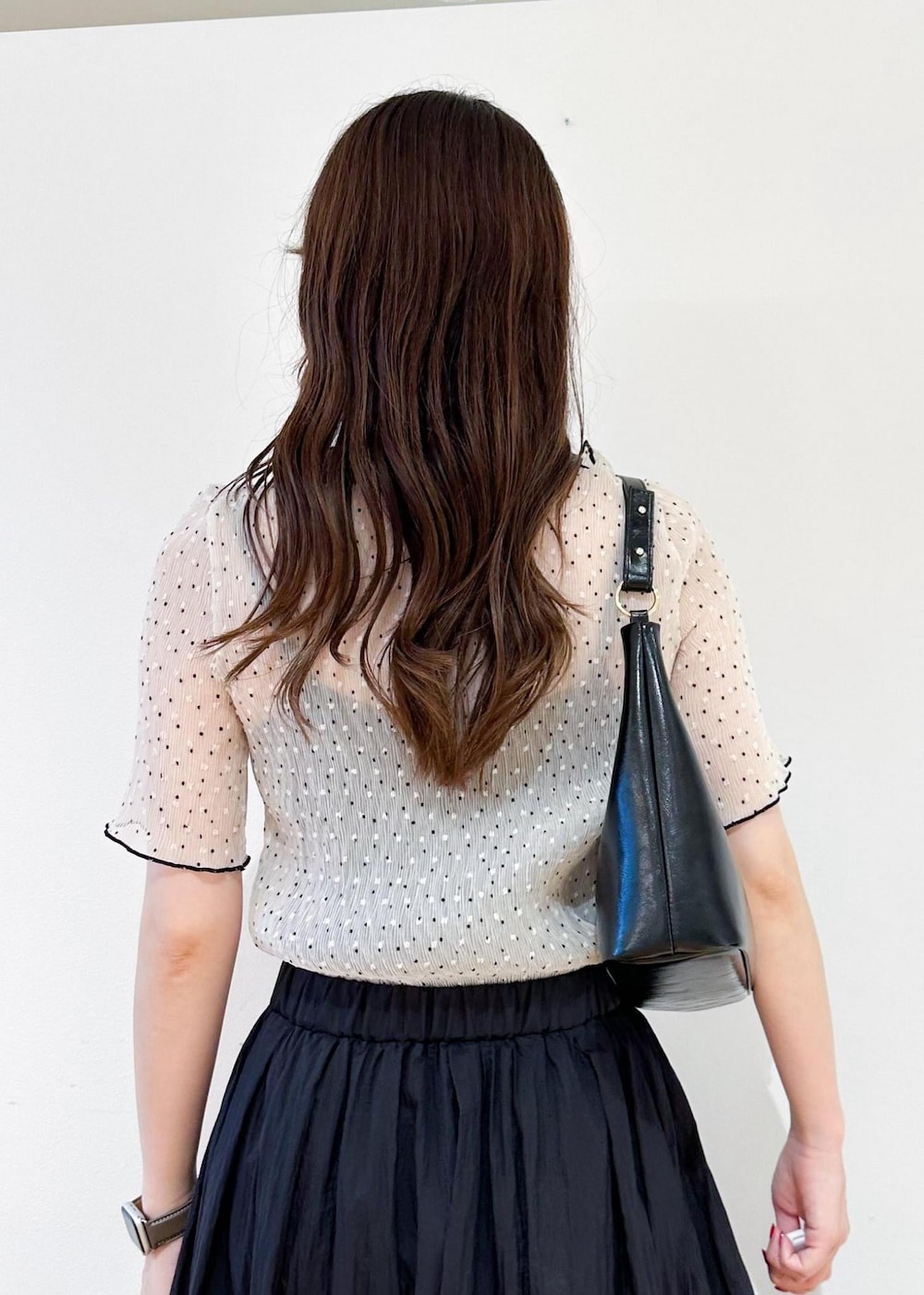 ブラック系のショルダーバッグ、グレー系のスカート、ホワイト系のシャツ/ブラウスを着用したレディースの夏コーディネートの6枚目の写真