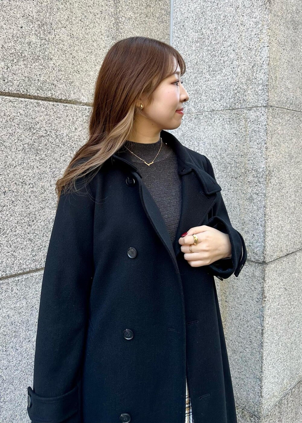 ブラウン系のショルダーバッグ、ブラック系のその他アウター、ホワイト系のスカートを着用したレディースの冬コーディネートの4枚目の写真