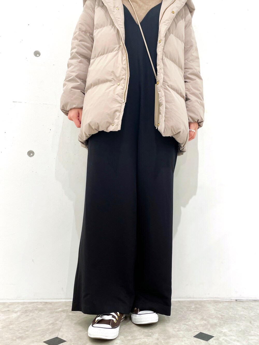 ブラウン系のダウンジャケット/コート、ブラック系のつなぎ/オールインワン、ブラウン系のニット/セーターを着用したレディースの冬コーディネートの5枚目の写真