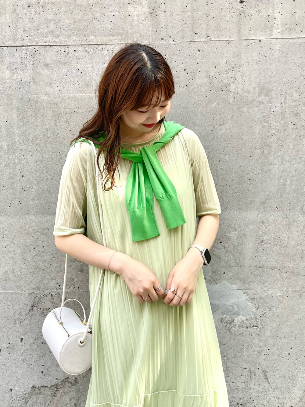 ホワイト系のサンダル、ホワイト系のドラムバッグ、グリーン系のカーディガン/ボレロを着用したレディースの夏コーディネートの3枚目の写真