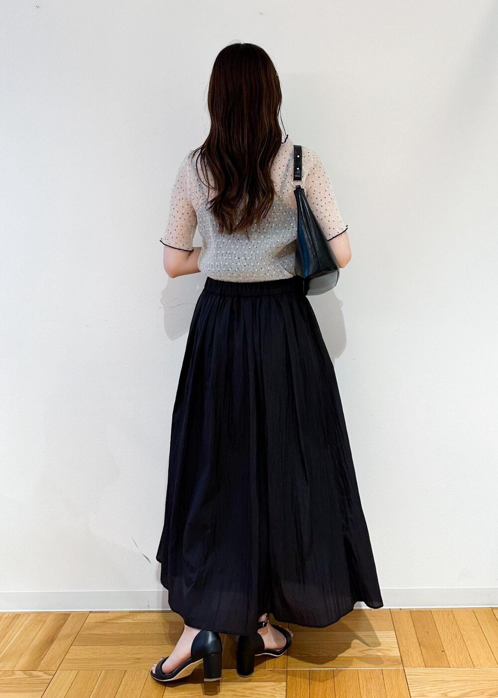 ブラック系のショルダーバッグ、グレー系のスカート、ホワイト系のシャツ/ブラウスを着用したレディースの夏コーディネートの4枚目の写真