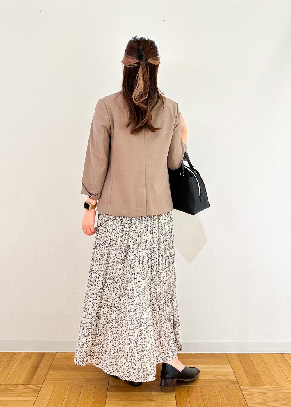 ベージュ系のスカート、ホワイト系のボストンバッグ、ブラウン系のテーラードジャケットを着用したレディースの夏コーディネートの3枚目の写真