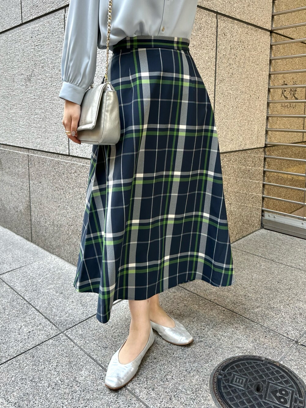 ブルー系のシャツ/ブラウス、ブルー系のスカート、シルバー系のショルダーバッグを着用したレディースの春コーディネートの5枚目の写真