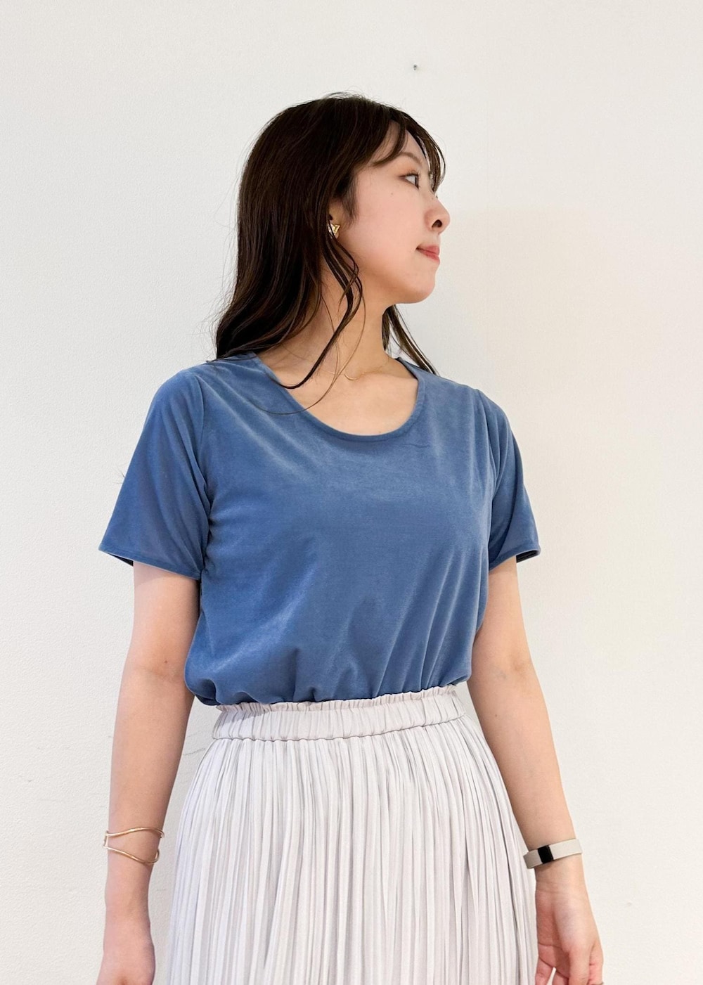 グレー系のスカート、ブラック系のショルダーバッグ、ブルー系のTシャツ/カットソーを着用したレディースの夏コーディネートの4枚目の写真