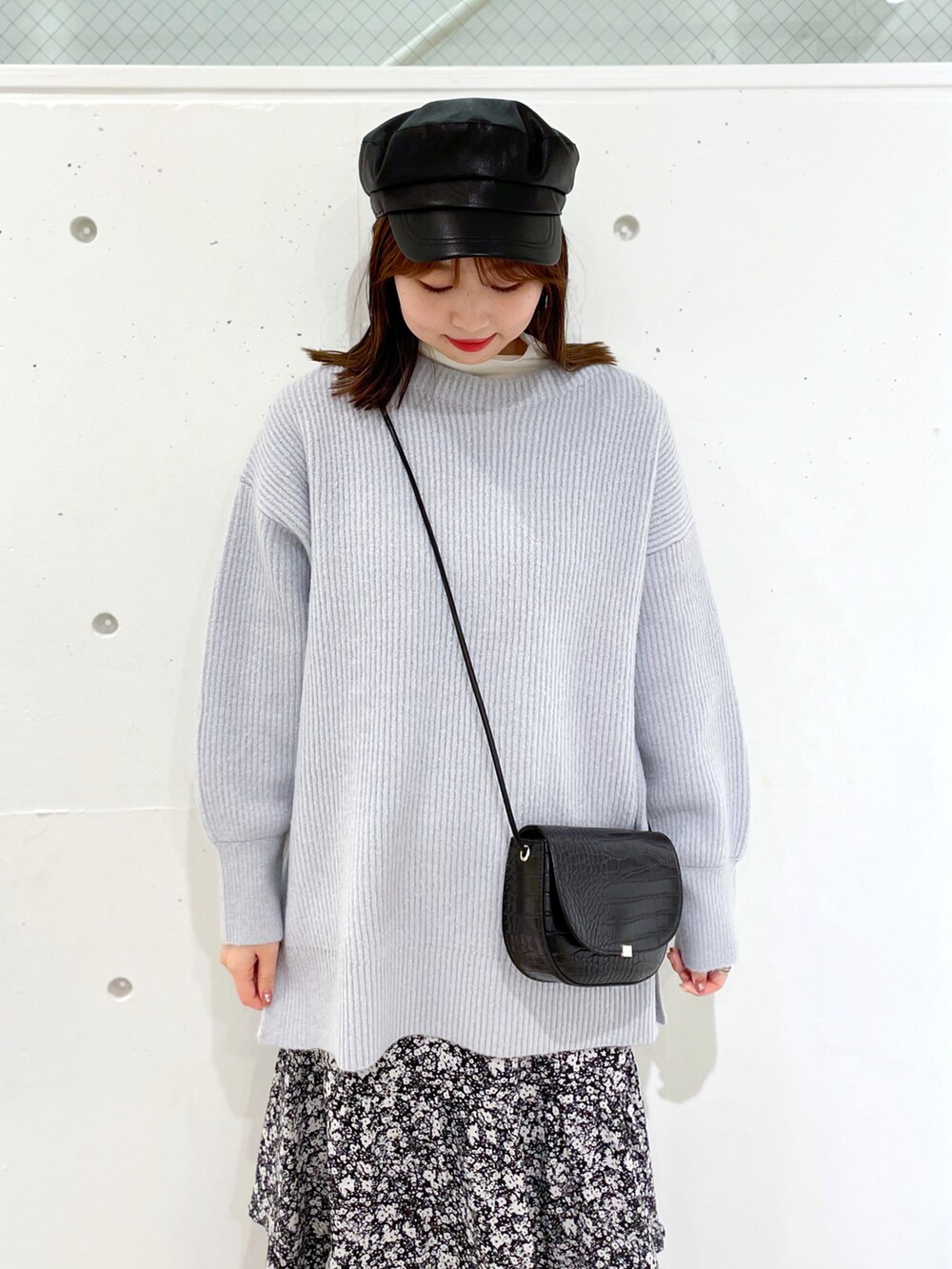 ブラック系のスカート、ブラック系のブーツ、ブルー系のニット/セーターを着用したレディースの冬コーディネートの3枚目の写真