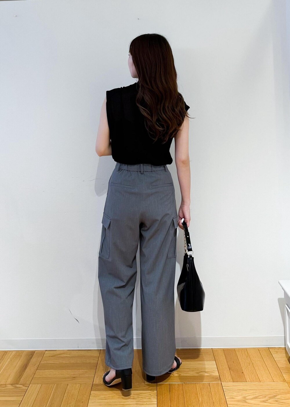 ブラック系のショルダーバッグ、グレー系のカーゴパンツ、ブラック系のニット/セーターを着用したレディースの夏コーディネートの3枚目の写真