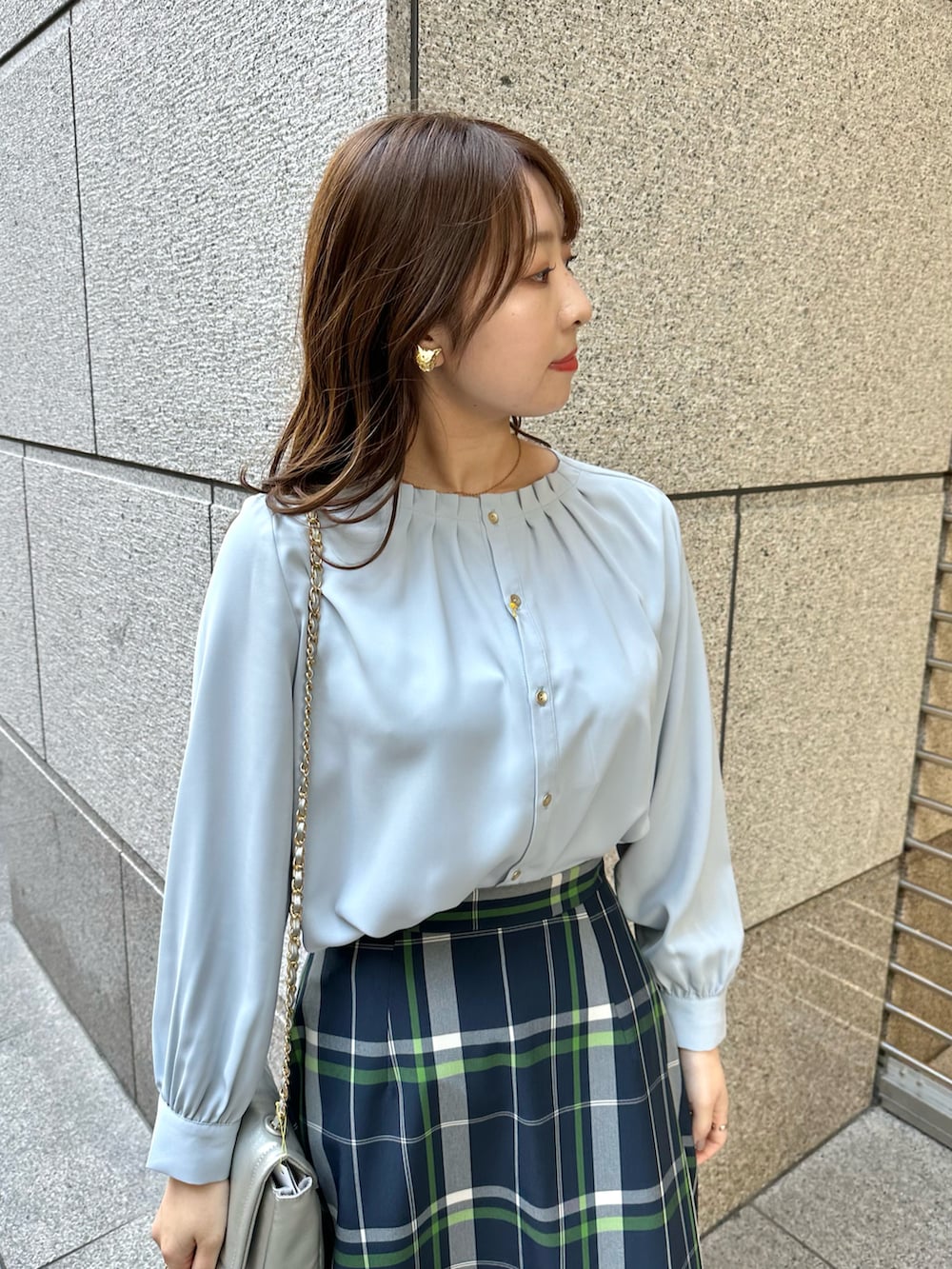 ブルー系のシャツ/ブラウス、ブルー系のスカート、シルバー系のショルダーバッグを着用したレディースの春コーディネートの3枚目の写真