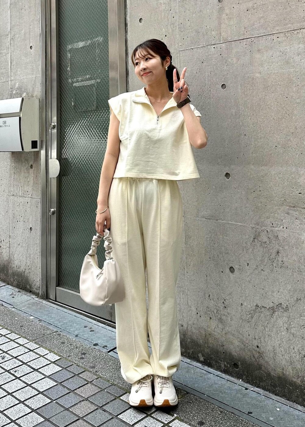 ホワイト系のTシャツ/カットソー、ホワイト系のスウェットパンツ、ホワイト系のハンドバッグを着用したレディースの春コーディネートの2枚目の写真