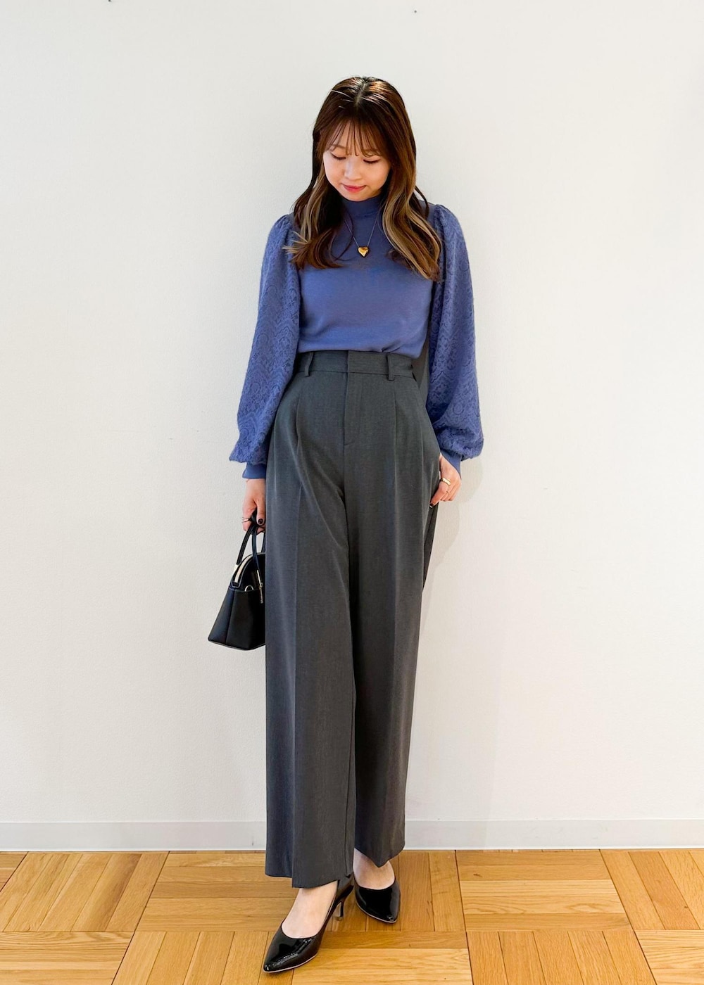 グレー系のその他パンツ、ブラック系のショルダーバッグ、ブルー系のニット/セーターを着用したレディースの秋コーディネートの2枚目の写真