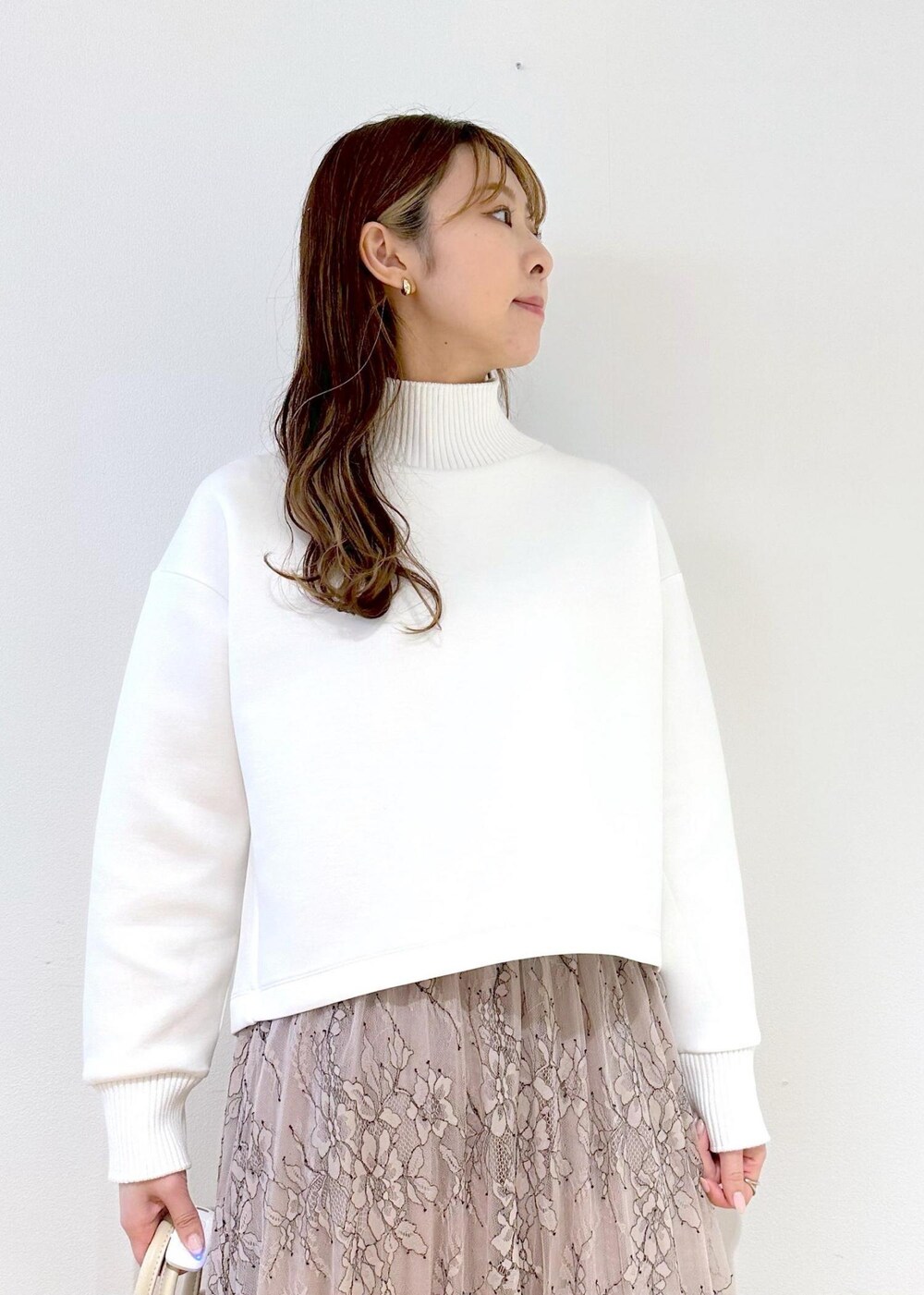 ホワイト系のハンドバッグ、ピンク系のスカート、ホワイト系のニット/セーターを着用したレディースの春コーディネートの4枚目の写真