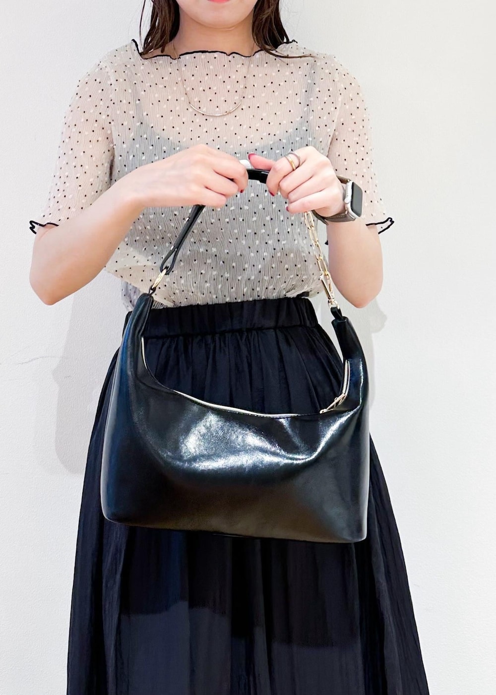 ブラック系のショルダーバッグ、グレー系のスカート、ホワイト系のシャツ/ブラウスを着用したレディースの夏コーディネートの7枚目の写真