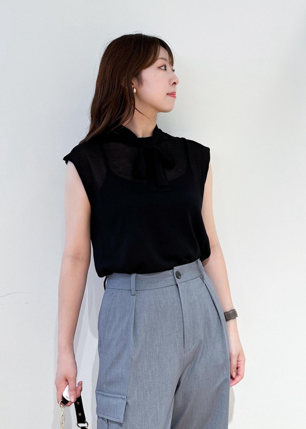 ブラック系のショルダーバッグ、グレー系のカーゴパンツ、ブラック系のニット/セーターを着用したレディースの夏コーディネートの4枚目の写真