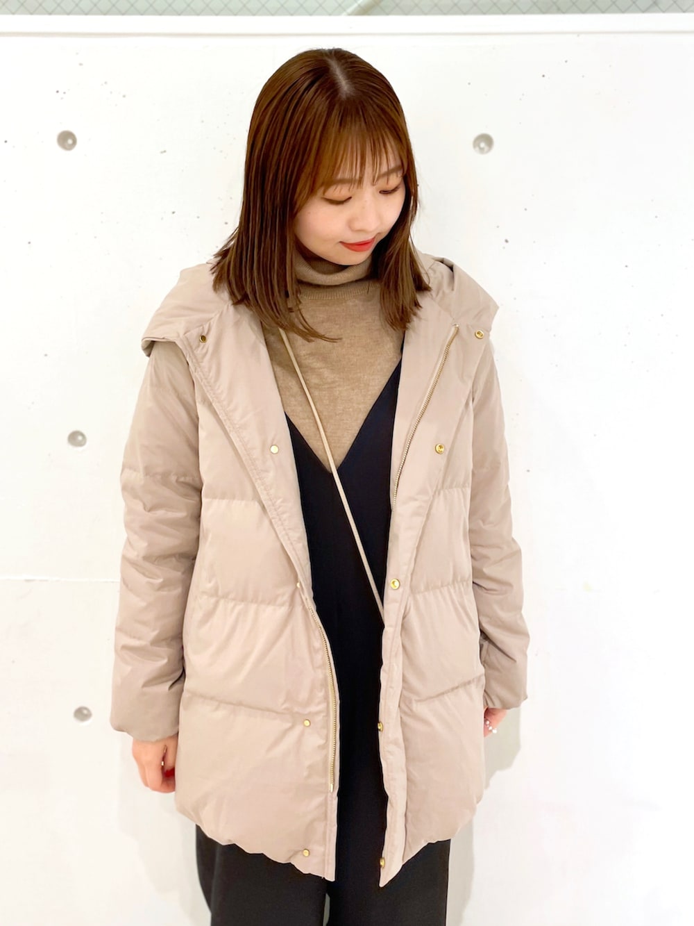 ブラウン系のダウンジャケット/コート、ブラック系のつなぎ/オールインワン、ブラウン系のニット/セーターを着用したレディースの冬コーディネートの3枚目の写真