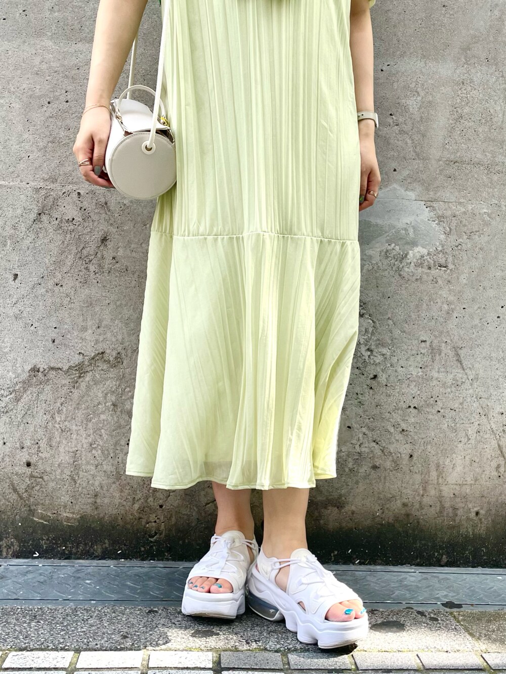ホワイト系のサンダル、ホワイト系のドラムバッグ、グリーン系のカーディガン/ボレロを着用したレディースの夏コーディネートの5枚目の写真