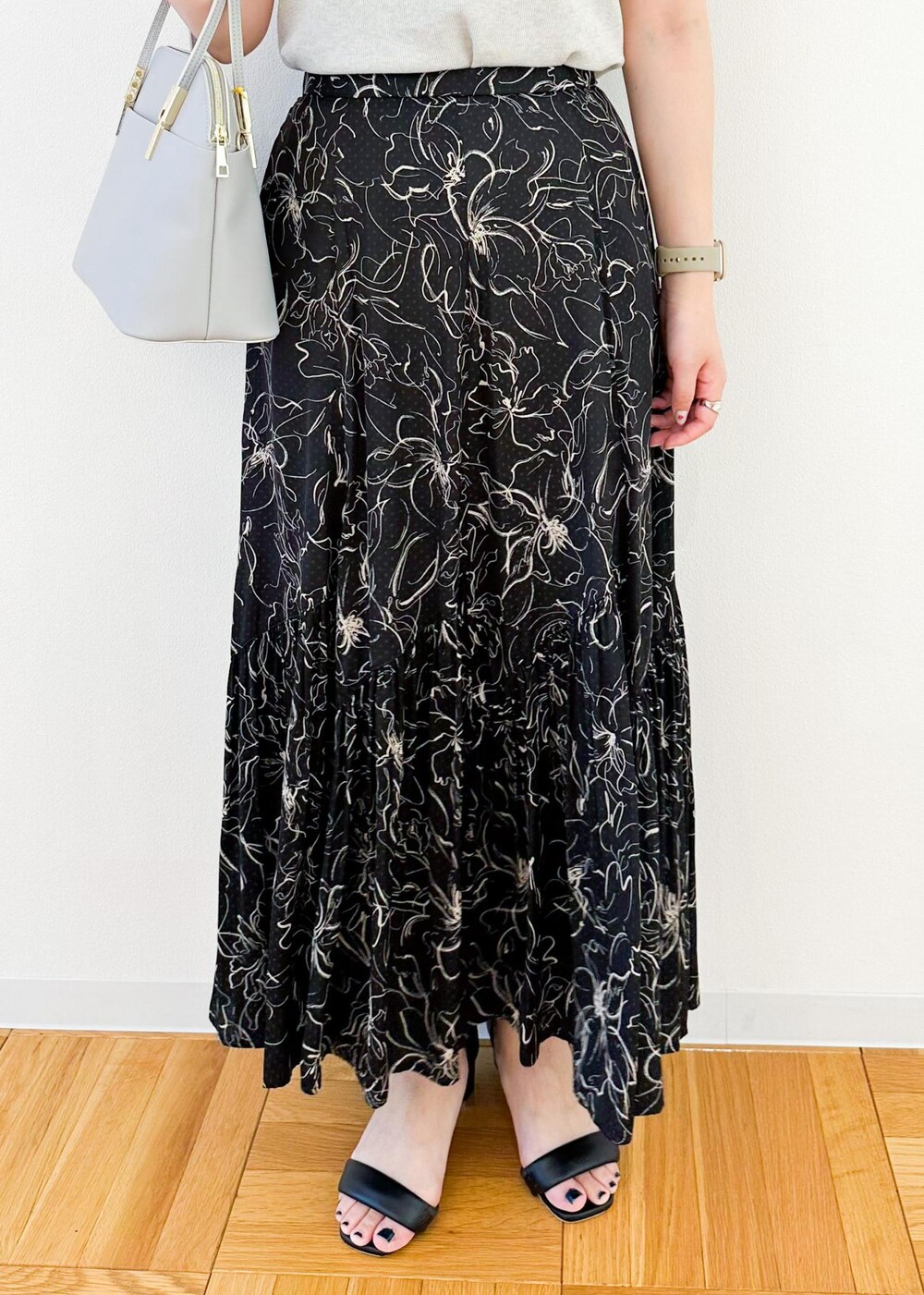 グレー系のニット/セーター、グレー系のショルダーバッグ、ブラック系のスカートを着用したレディースの夏コーディネートの7枚目の写真