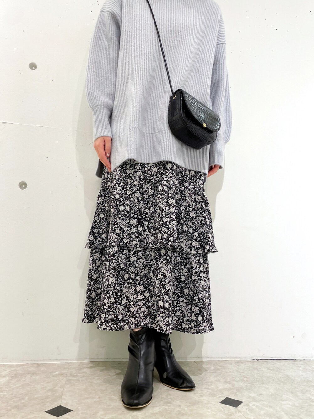 ブラック系のスカート、ブラック系のブーツ、ブルー系のニット/セーターを着用したレディースの冬コーディネートの5枚目の写真