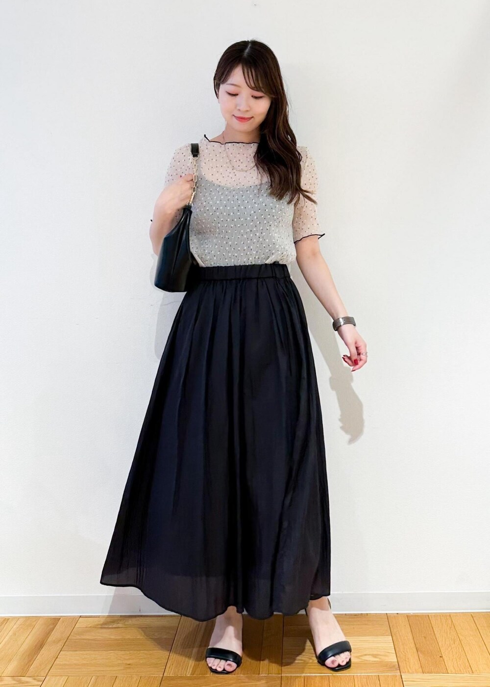 ブラック系のショルダーバッグ、グレー系のスカート、ホワイト系のシャツ/ブラウスを着用したレディースの夏コーディネートの2枚目の写真