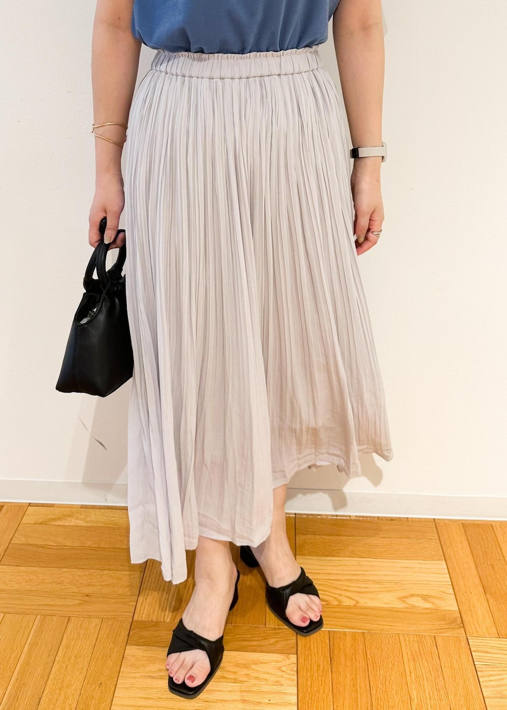 グレー系のスカート、ブラック系のショルダーバッグ、ブルー系のTシャツ/カットソーを着用したレディースの夏コーディネートの6枚目の写真